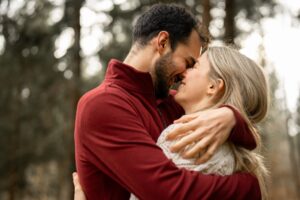 Couple embracing closely with their foreheads together while smiling at each other