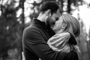 Black-and-white photo of a couple embracing closely with their foreheads touching