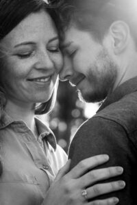 Black-and-white close-up of an intimate moment with a couple leaning their heads together and closing their eyes