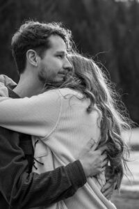 Cinematic black-and-white photo of a young couple sharing an intimate embrace