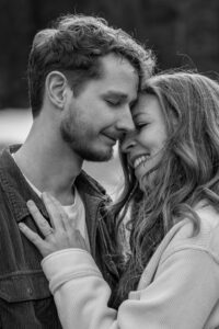 Black-and-white photo of a romantic couple with their heads leaning together