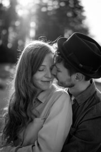 Romantic dreamy black-and-white photo of a young couple sharing a kiss on the cheek