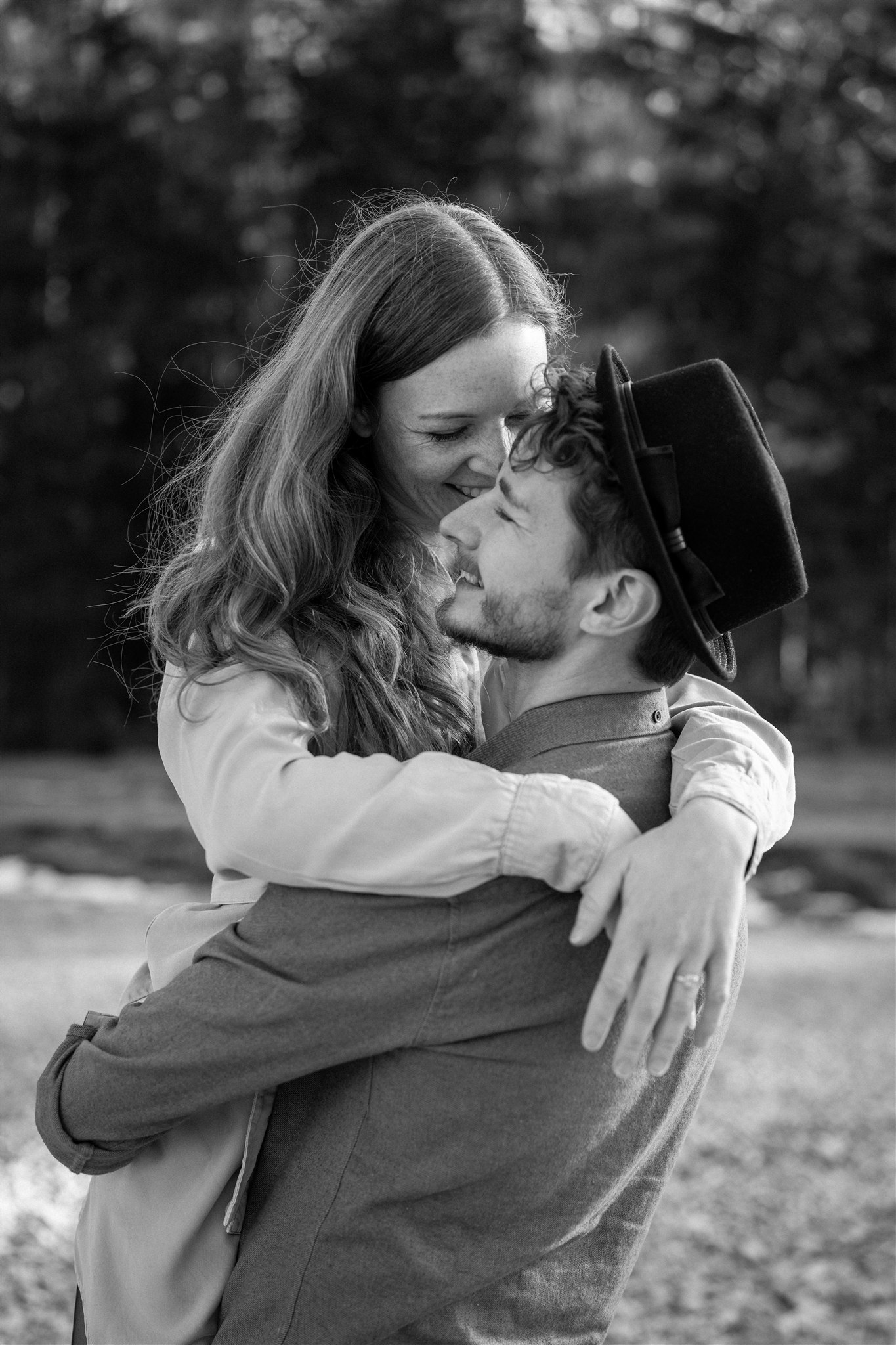 Black-and-white photo of an intimate embrace as the bride is lifted by her husband