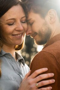 Close-up in golden light of an intimate moment with a couple leaning their heads together
