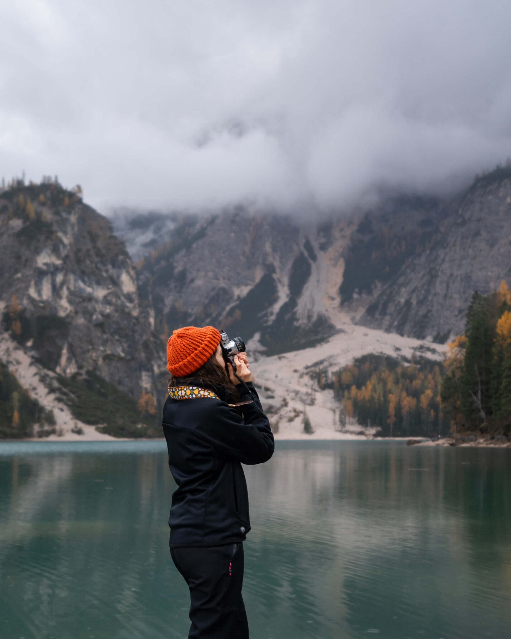 Caro photographing a mountain lake in South Tyrol during rainy autumn weather
