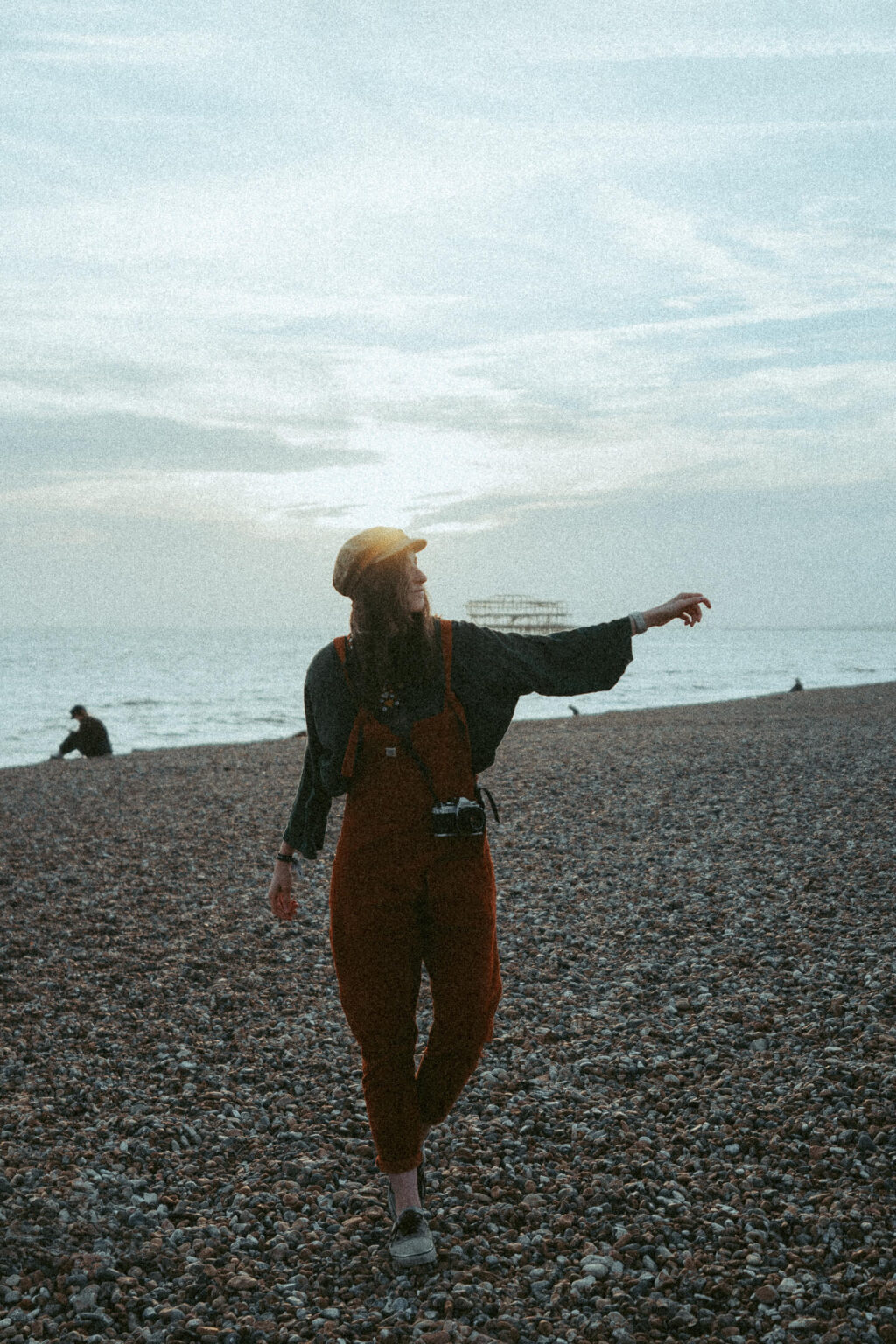 Analog photo of photographer Caro playfully walking along the beach while gazing into the surroundings