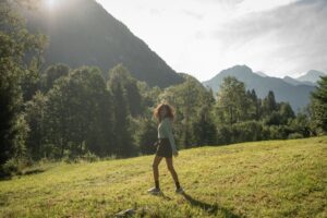 Vintage cinematic photo of a young Indian woman in a wide field within the Swiss mountains