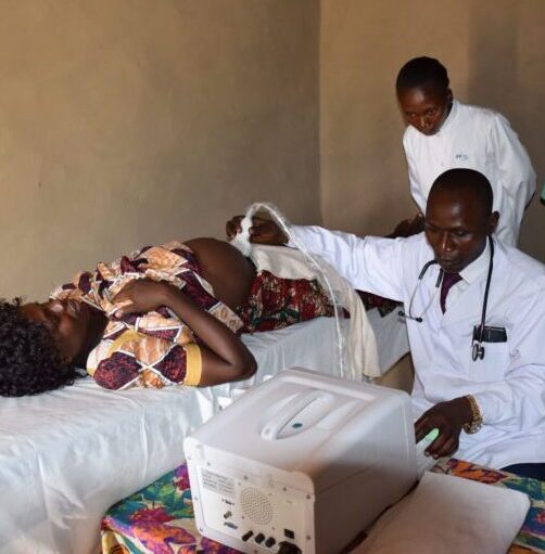 Two African doctors performing an ultrasound examination on a pregnant woman